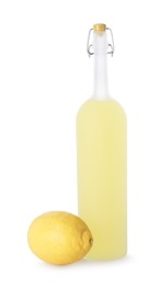 Photo of Bottle of tasty limoncello liqueur and lemon isolated on white