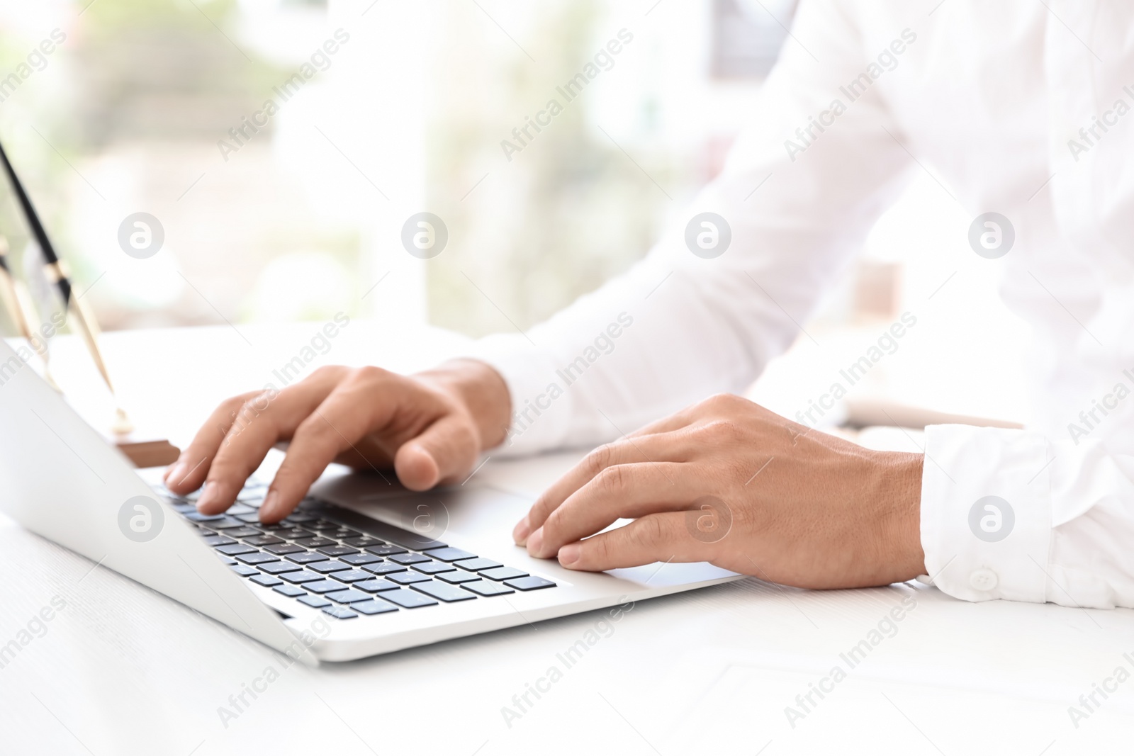 Photo of Male notary working with laptop at table in office, closeup