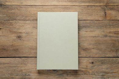 Closed hardcover book on wooden table, top view