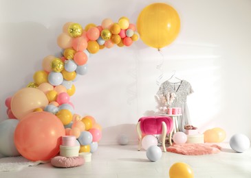 Balloon garland near white wall in room. Festive decor