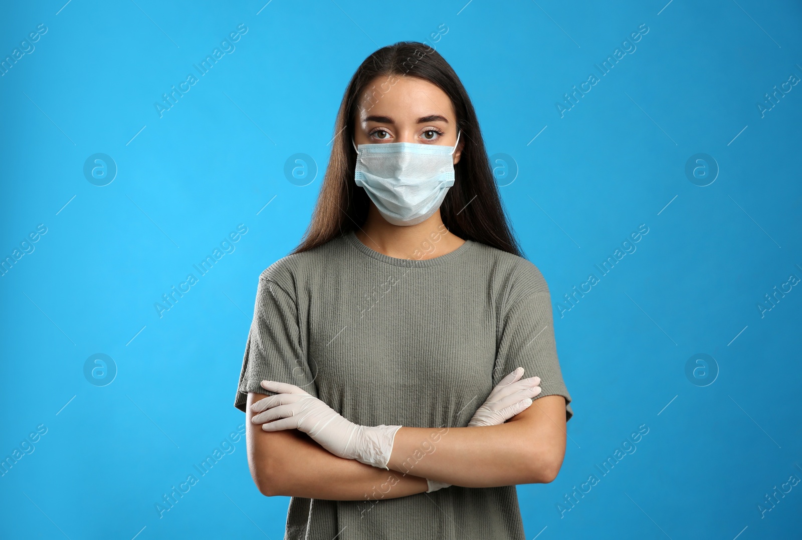 Photo of Woman wearing protective face mask and medical gloves on blue background