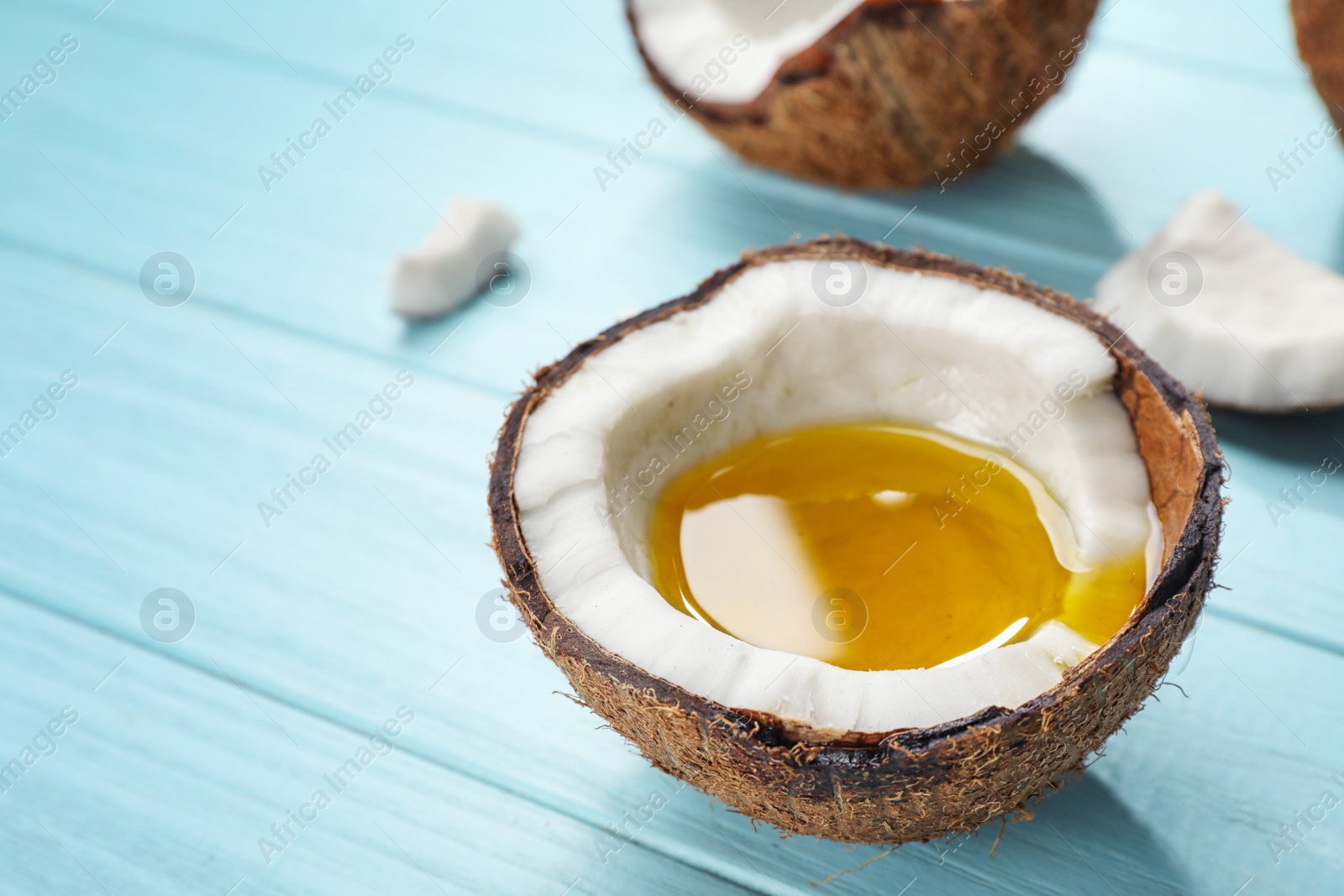 Photo of Ripe coconut with oil on table. Healthy cooking