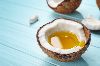 Photo of Ripe coconut with oil on table. Healthy cooking