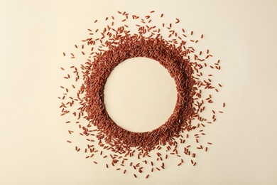 Photo of Round frame made with brown rice on color background, top view. Space for text