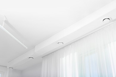 Photo of White ceiling with modern lighting in office