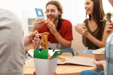 Photo of Young people having lunch together at home. Food delivery