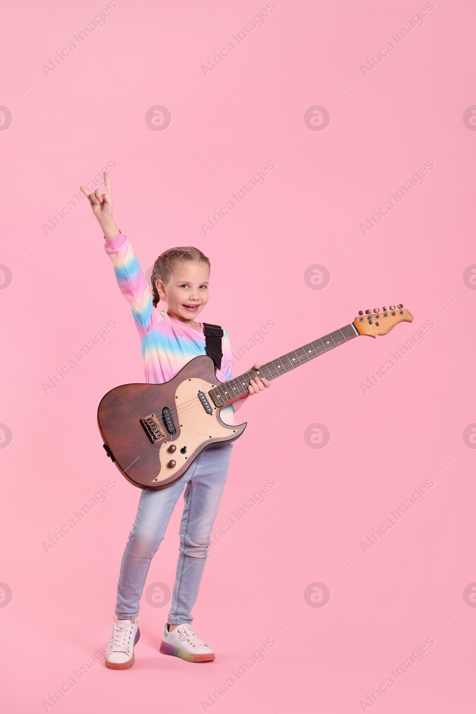 Photo of Cute girl with electric guitar on pink background