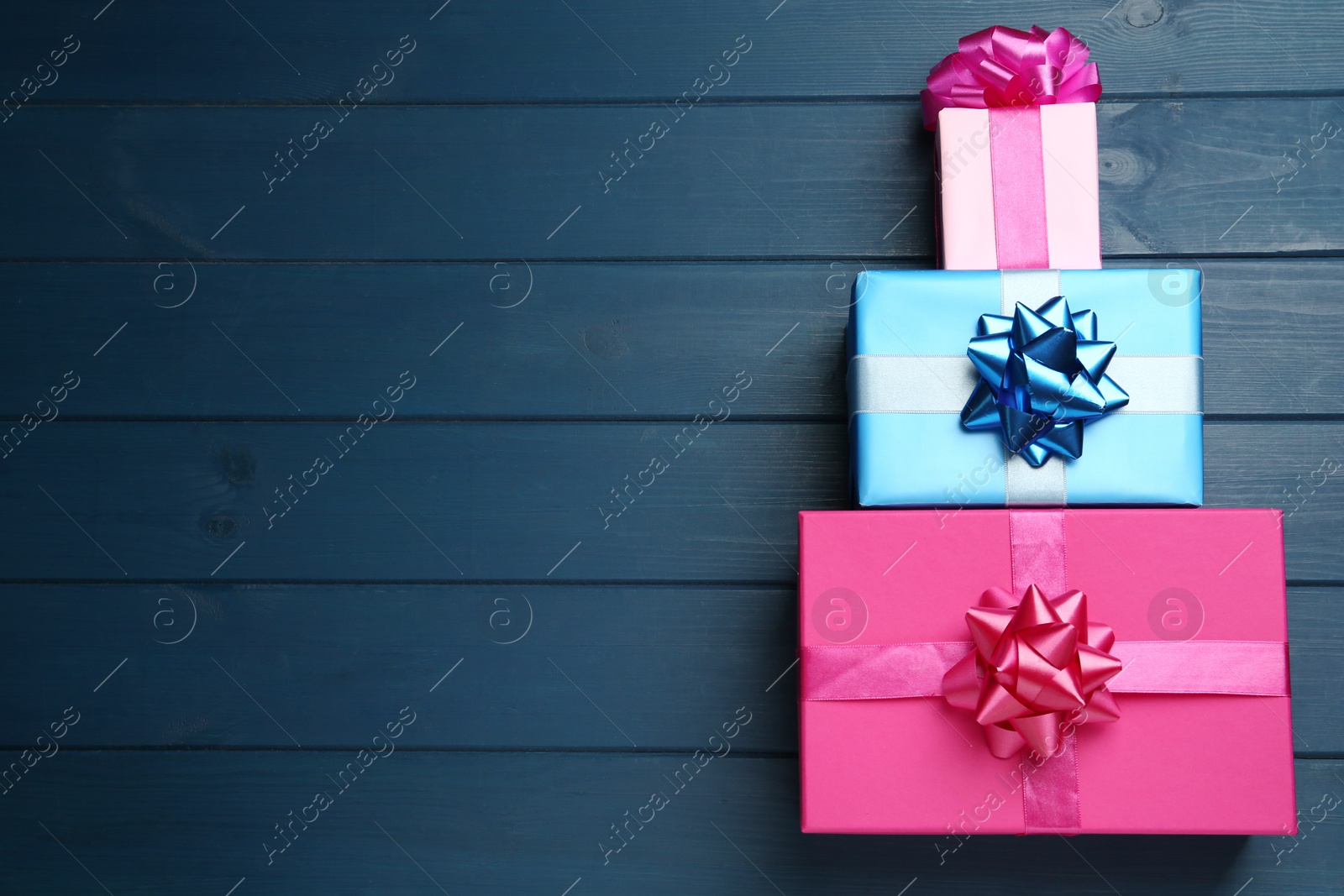 Photo of Colorful gift boxes on blue wooden table, flat lay. Space for text