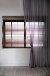 Photo of Window with beautiful curtain and blinds in empty room