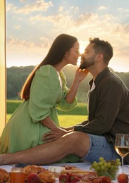 Romantic date. Beautiful couple kissing during picnic on sunny day