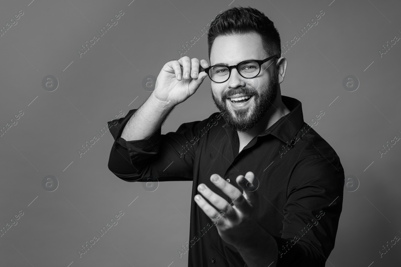 Photo of Portrait of handsome bearded man on grey background. Black and white effect