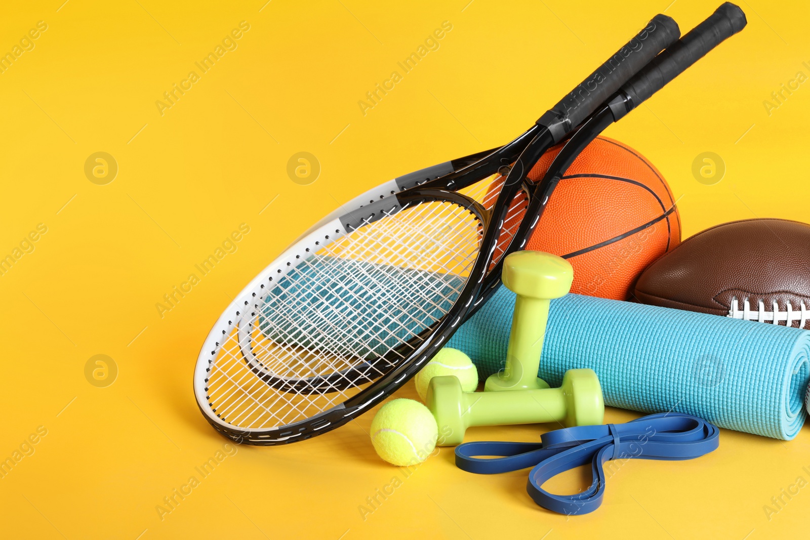 Photo of Set of different sports equipment on yellow background