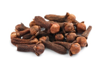 Pile of aromatic dry cloves on white background