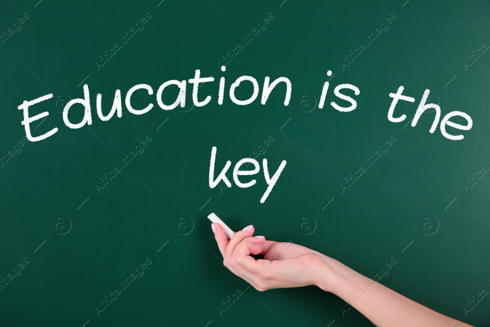 Image of Woman writing phrase Education is the key on chalkboard, closeup. Adult learning