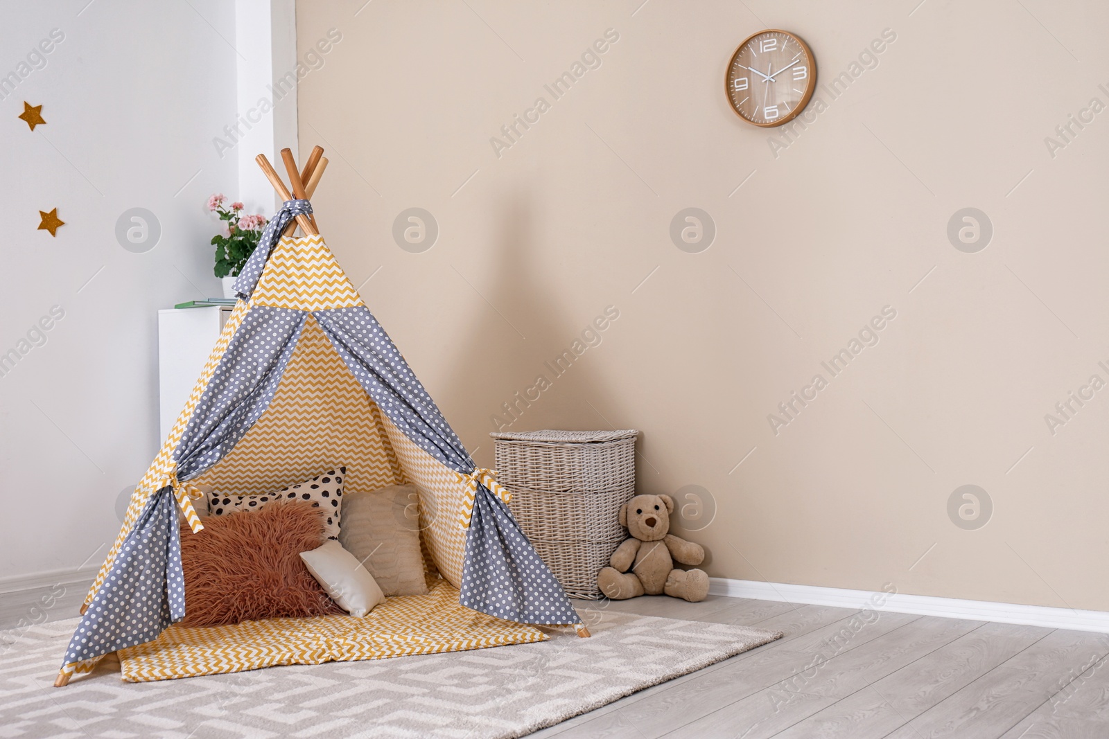 Photo of Cozy kids room interior with play tent and toys. Space for text