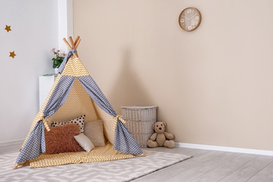 Cozy kids room interior with play tent and toys. Space for text