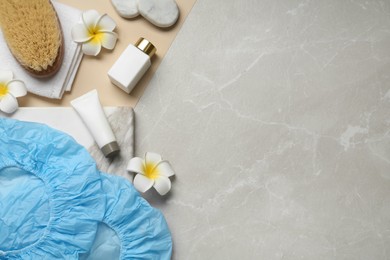 Photo of Flat lay composition with shower caps and toiletries on color background. Space for text