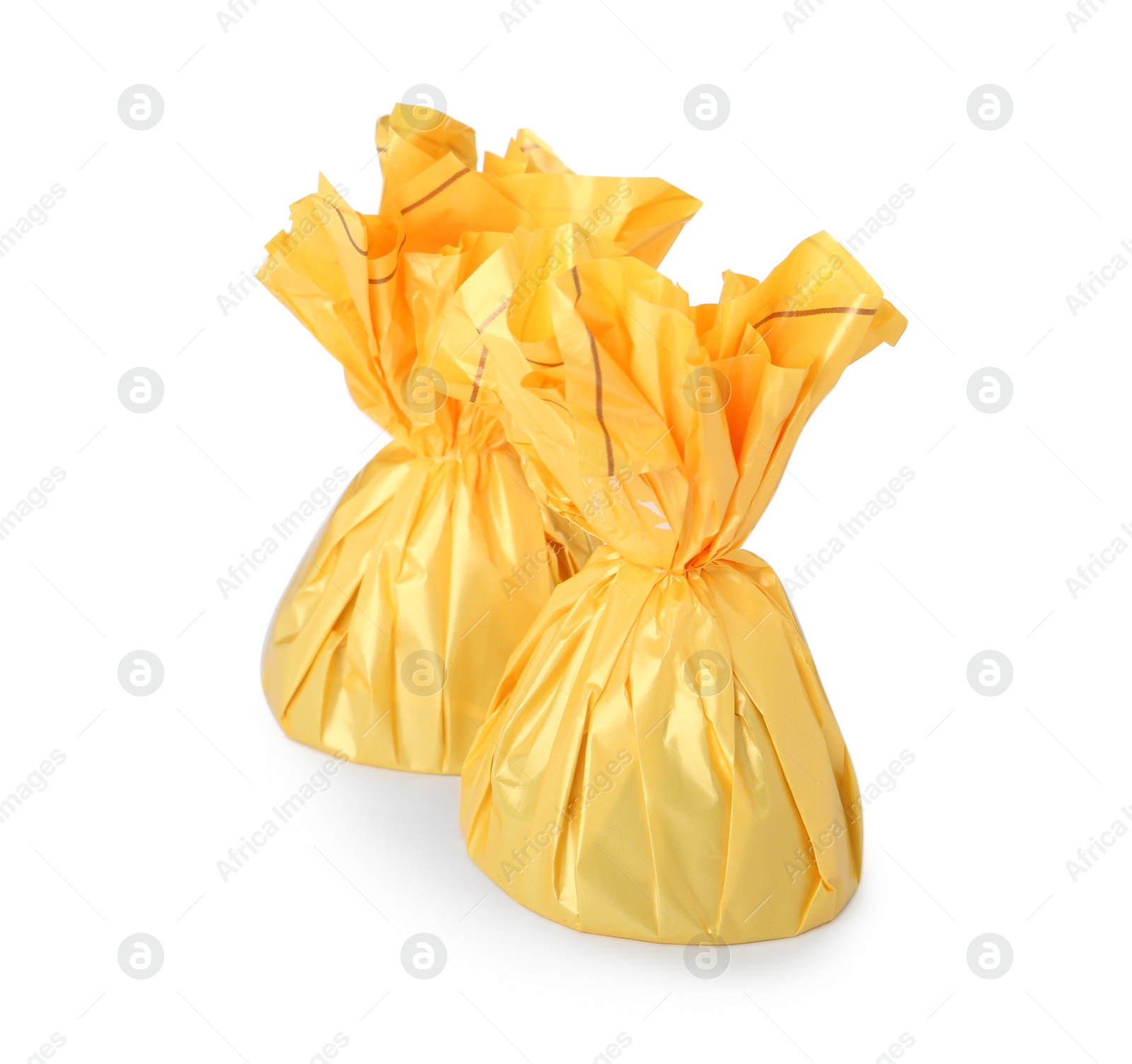 Photo of Delicious candies in yellow wrappers on white background