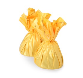 Photo of Delicious candies in yellow wrappers on white background