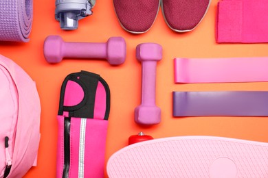 Photo of Different sports equipment on orange background, flat lay