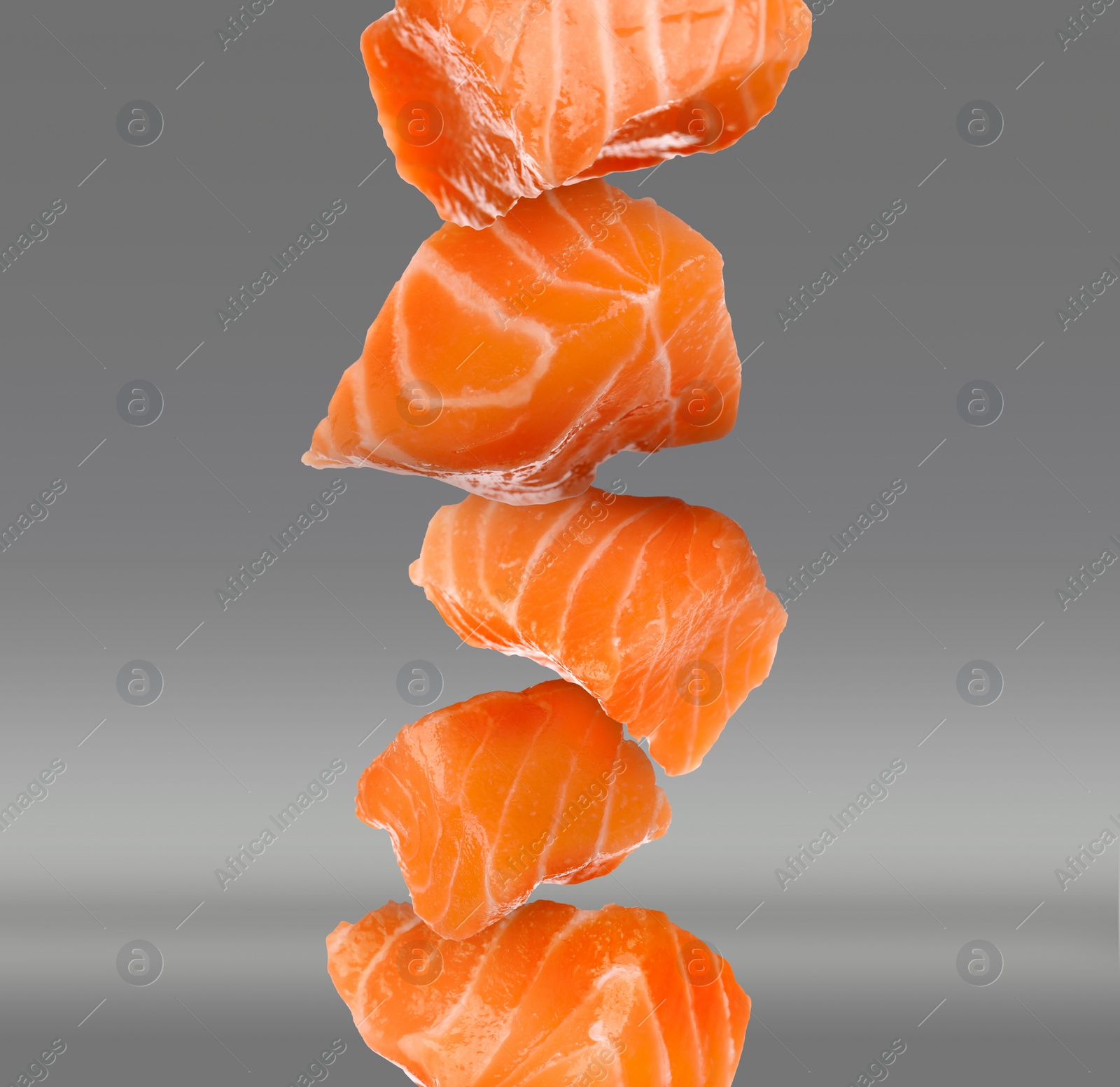 Image of Cut fresh salmon falling on grey background