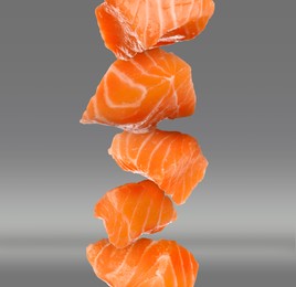 Image of Cut fresh salmon falling on grey background