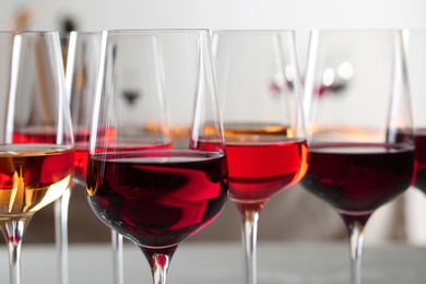 Photo of Glasses with different wines on blurred background, closeup
