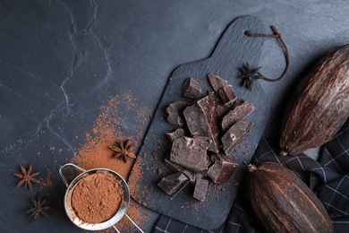 Flat lay composition with tasty dark chocolate on black table