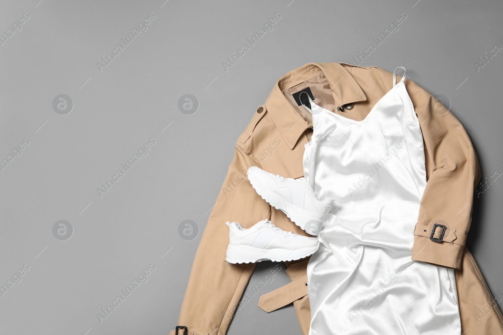 Photo of Stylish white dress and coat on grey background, flat lay. Space for text