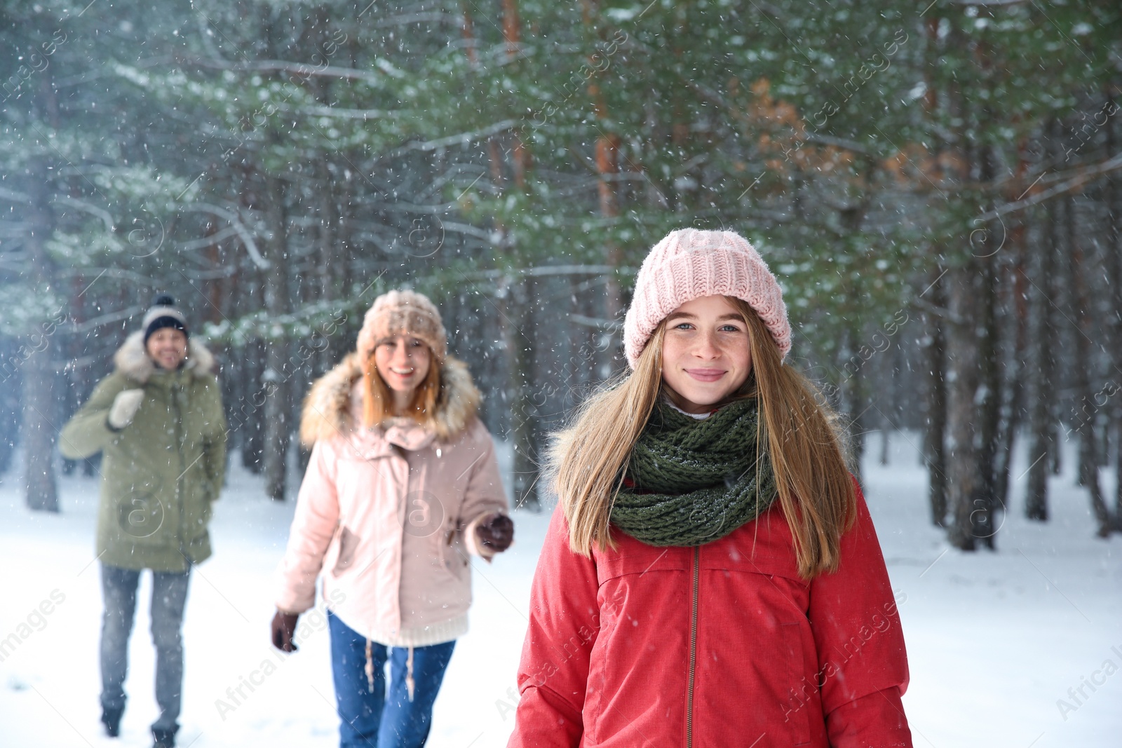 Photo of Teenage girl with family in snowy winter forest