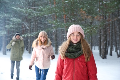 Photo of Teenage girl with family in snowy winter forest