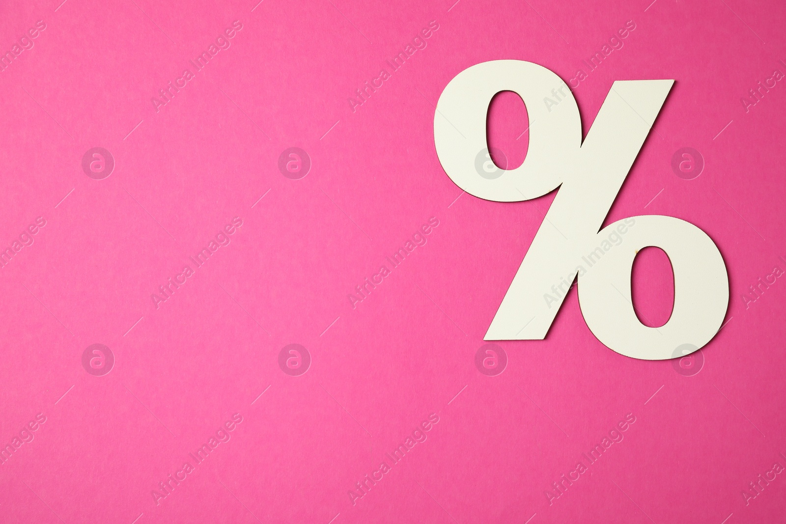 Photo of White percent sign on pink background, top view. Space for text