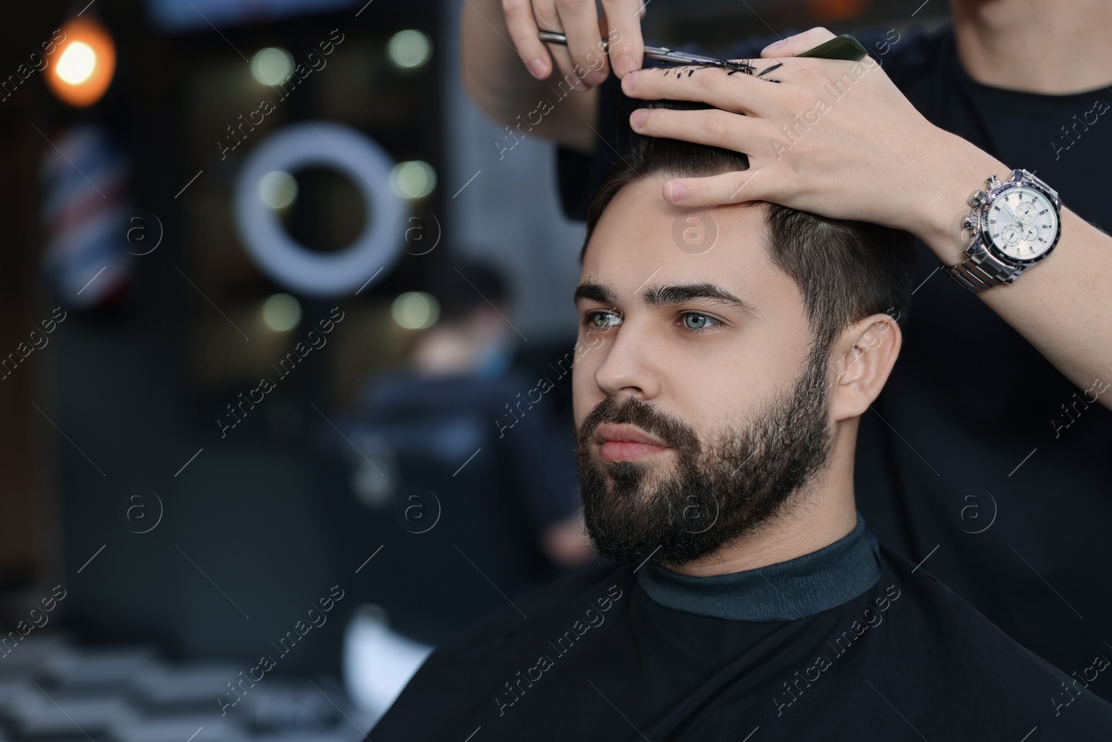 Photo of Professional hairdresser working with client in barbershop