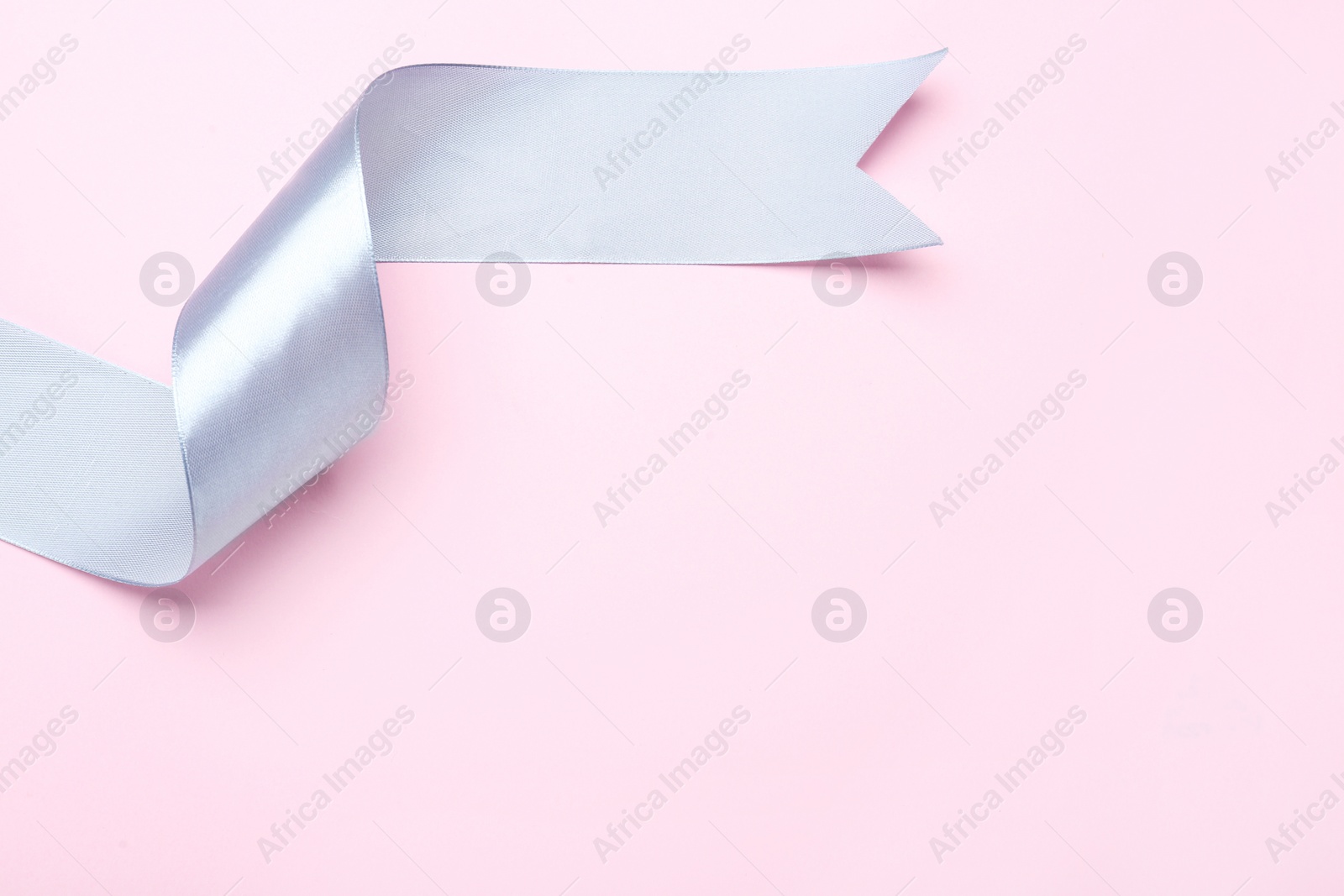 Photo of Beautiful ribbon on pink background, top view. Space for text