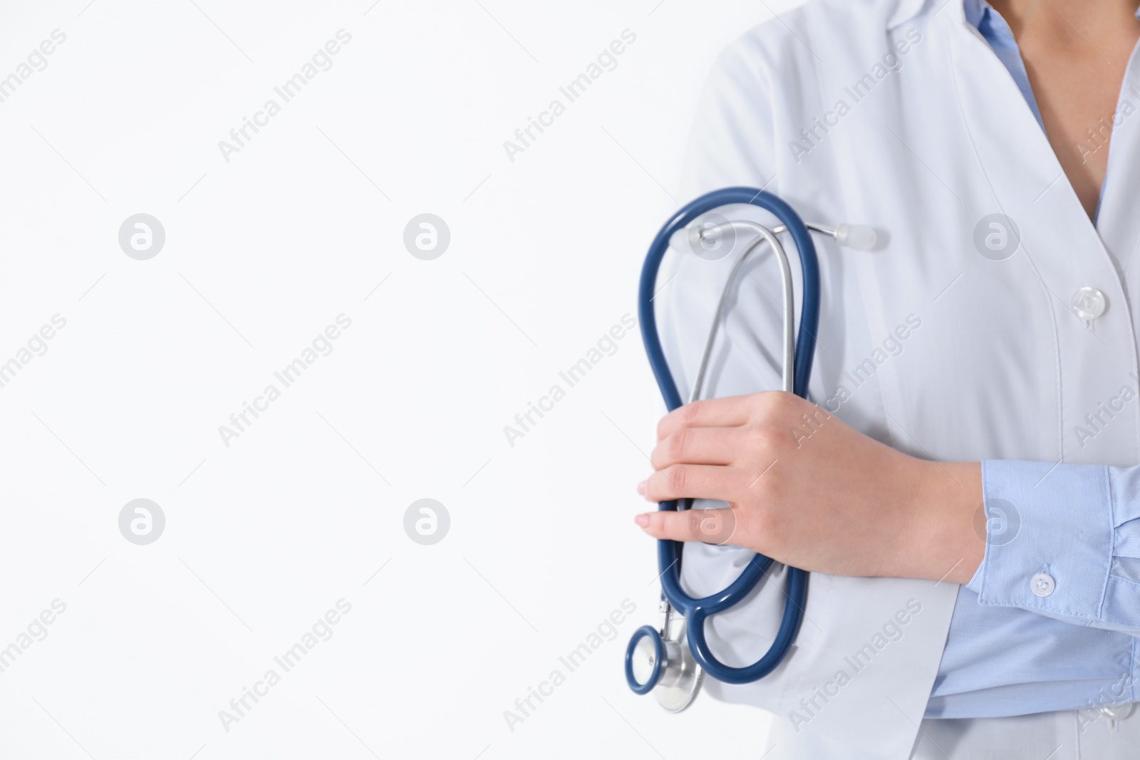 Photo of Young doctor with stethoscope on white background, closeup