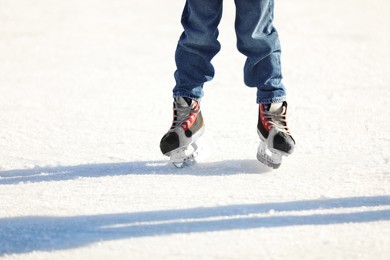 Photo of Little child at outdoor ice skating rink, closeup