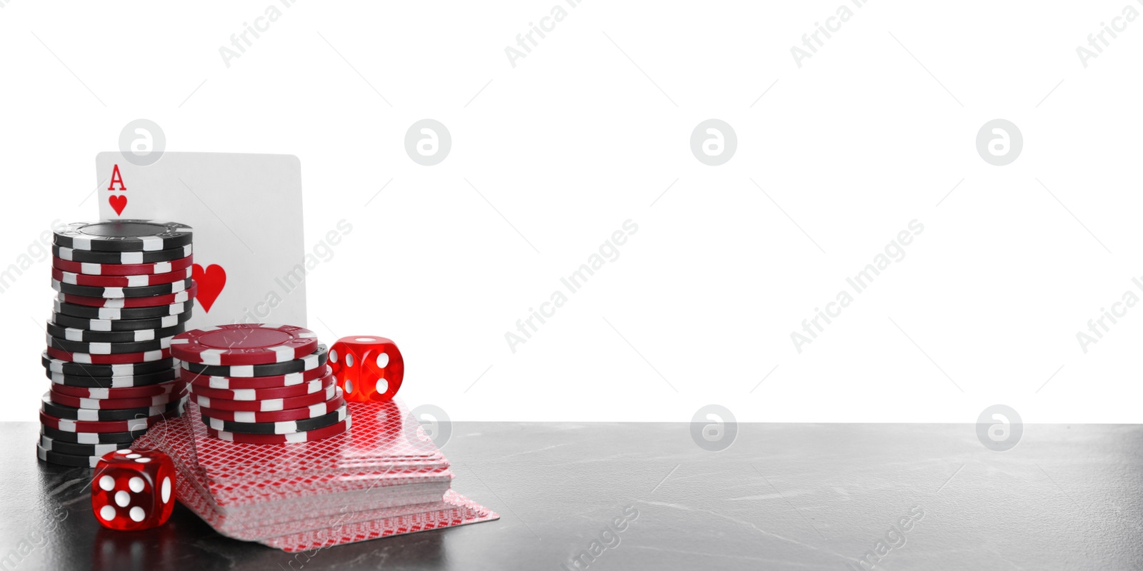 Photo of Gaming chips, dices and cards on table against white background
