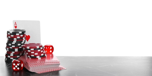 Photo of Gaming chips, dices and cards on table against white background