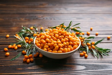 Photo of Fresh ripe sea buckthorn on wooden table