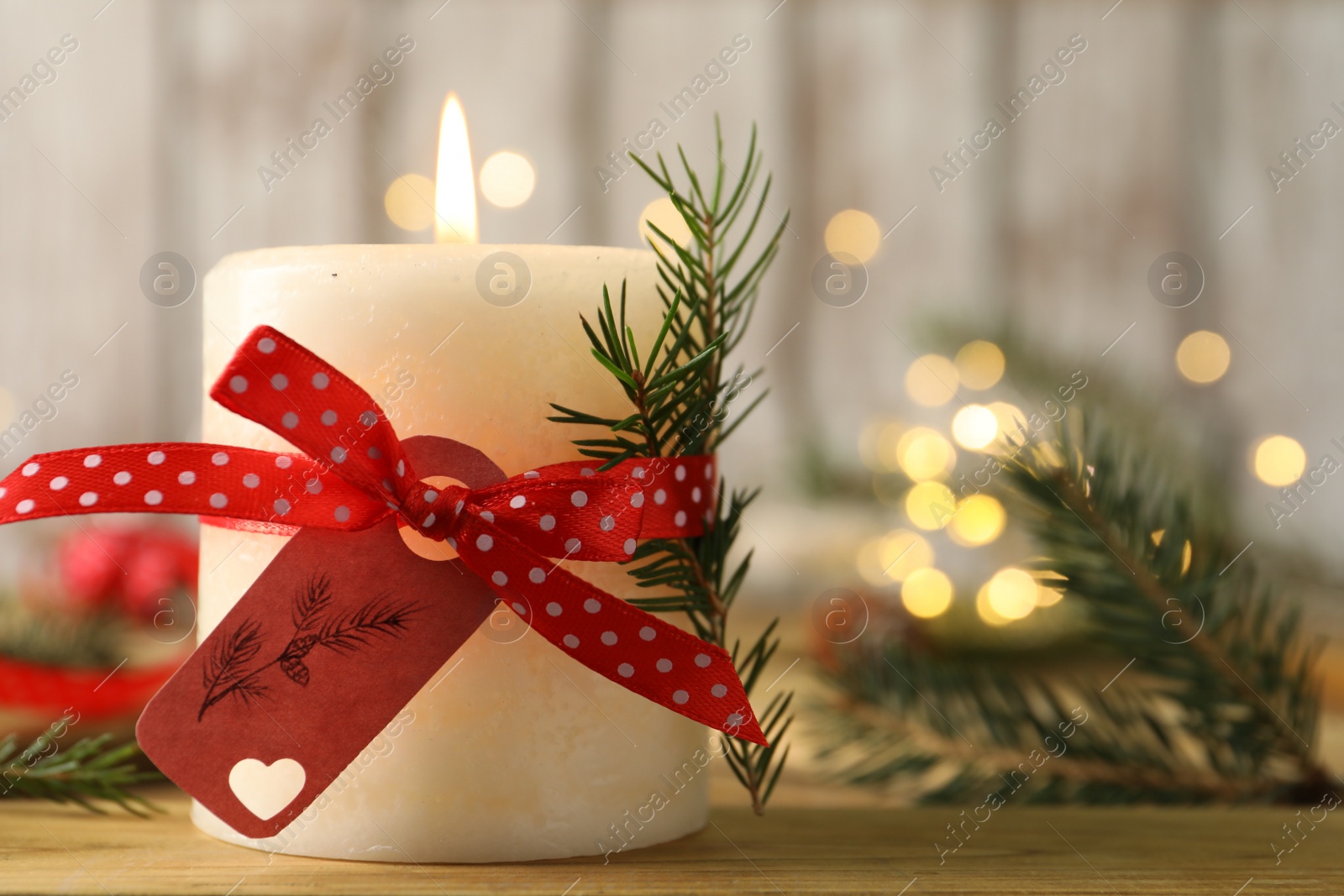 Photo of Burning candle with pinecone scent on wooden table, closeup. Space for text