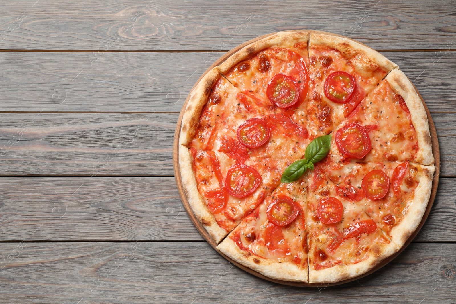 Photo of Delicious pizza Margherita on wooden table, top view. Space for text