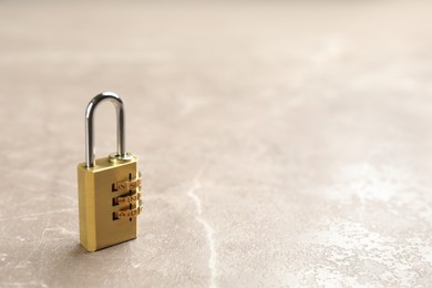 Modern combination lock on grey marble table. Space for text