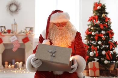 Authentic Santa Claus with gift box indoors