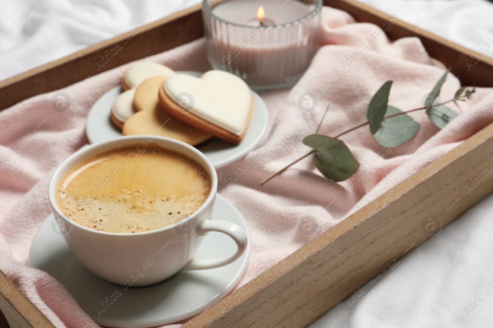 Photo of Wooden tray with coffee and cookies on bed. Romantic breakfast
