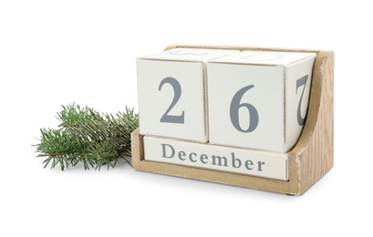 Wooden block calendar with date 26th of December near fir tree branch on white background. Boxing day