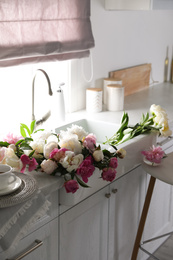 Photo of Bunch of beautiful peonies in kitchen sink