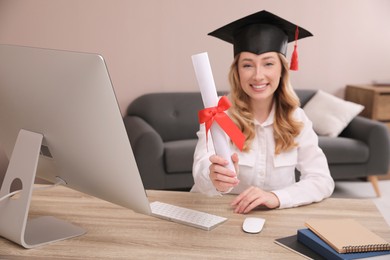 Photo of Happy student with graduation hat at workplace in office, focus on diploma