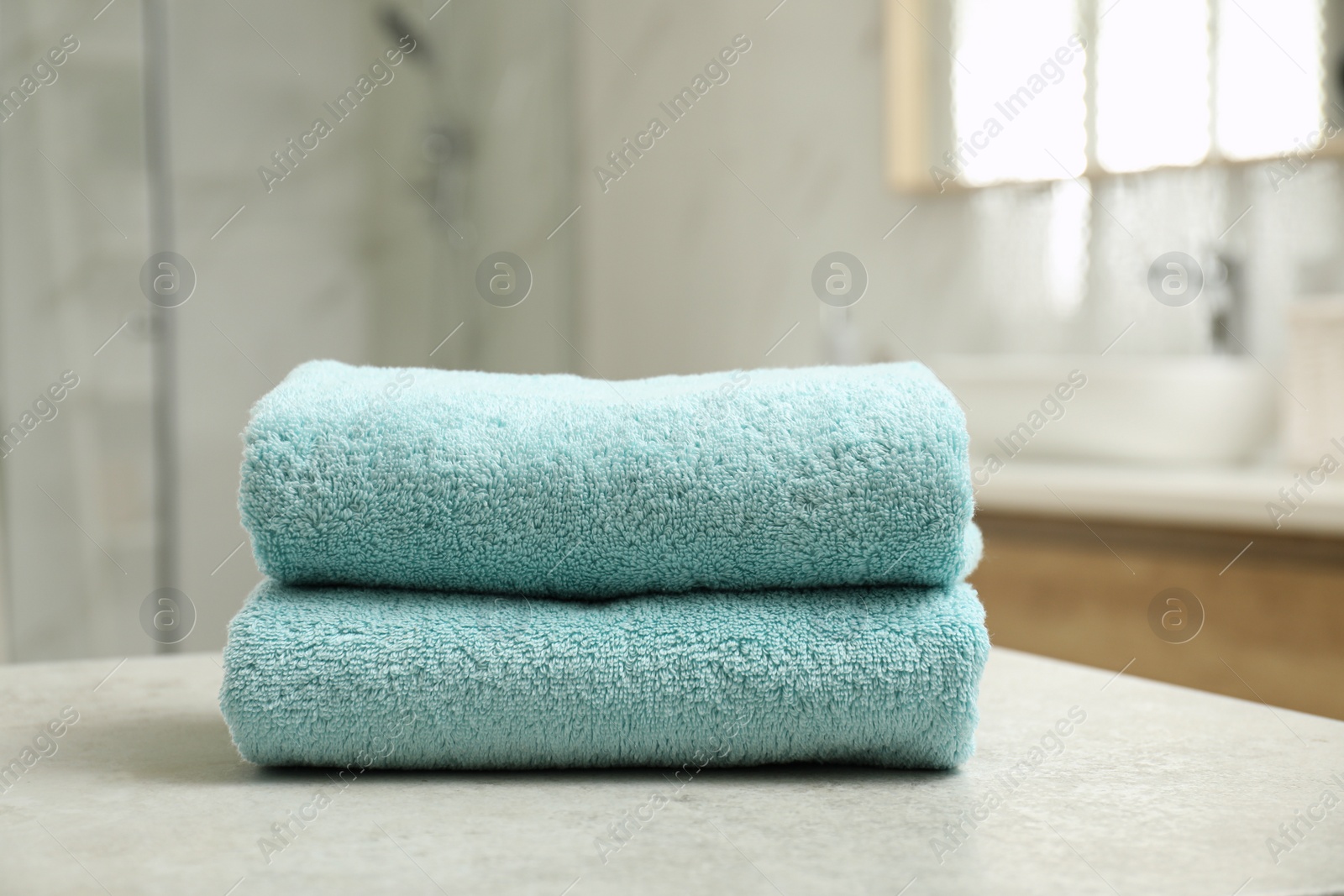 Photo of Stack of clean towels on table indoors