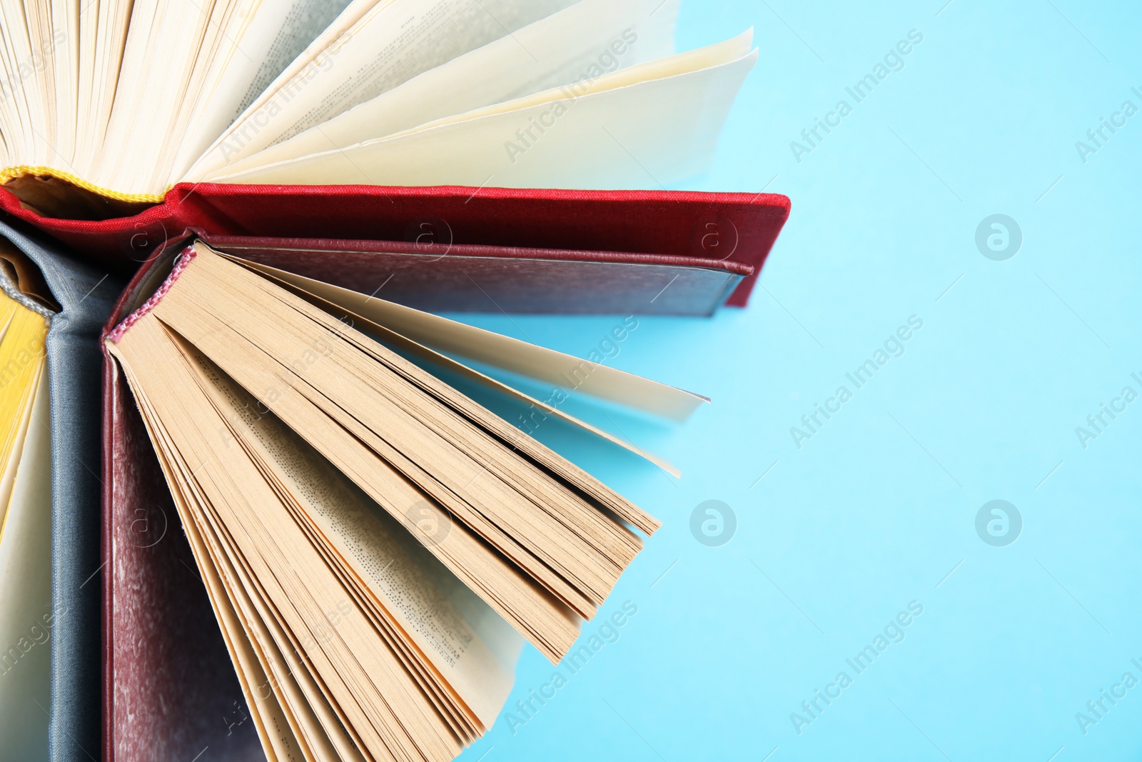 Photo of Hardcover books on light blue background, flat lay