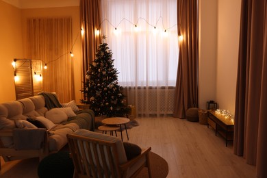 Photo of Tv area with cabinet, comfortable furniture and Christmas tree in stylish room